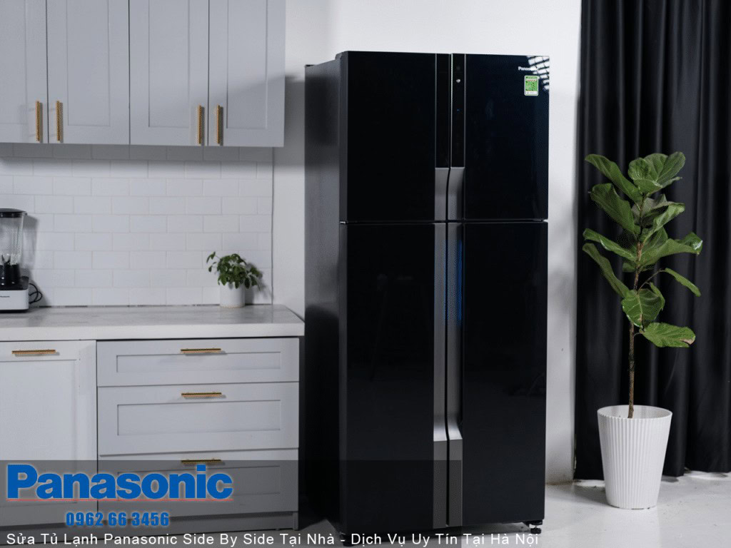 Black Panasonic refrigerator in modern kitchen with white cabinets and green plant.